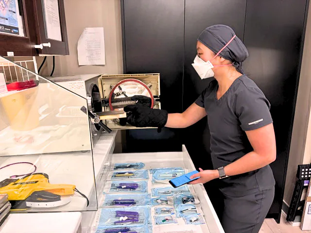 Dental team member operating the instrument sterilizer