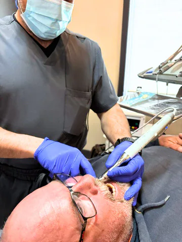 Dentist using an intraoral scanner during patient treatment